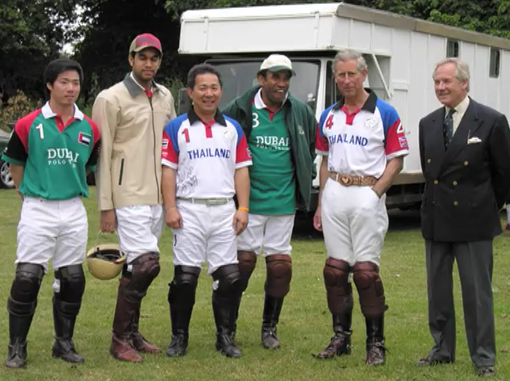 Prince Charles near other polo players on the field near the truck