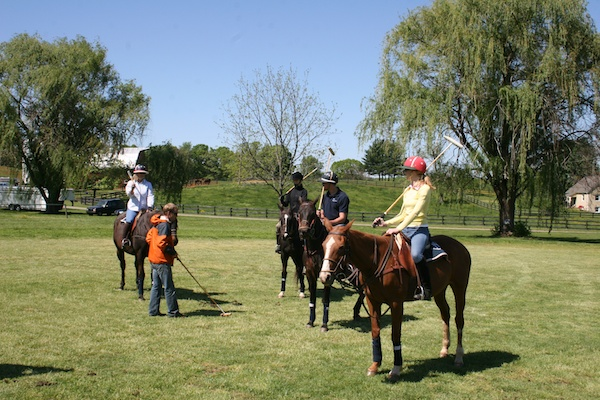 Several people on horseback and an instructor who teaches the rules of the game