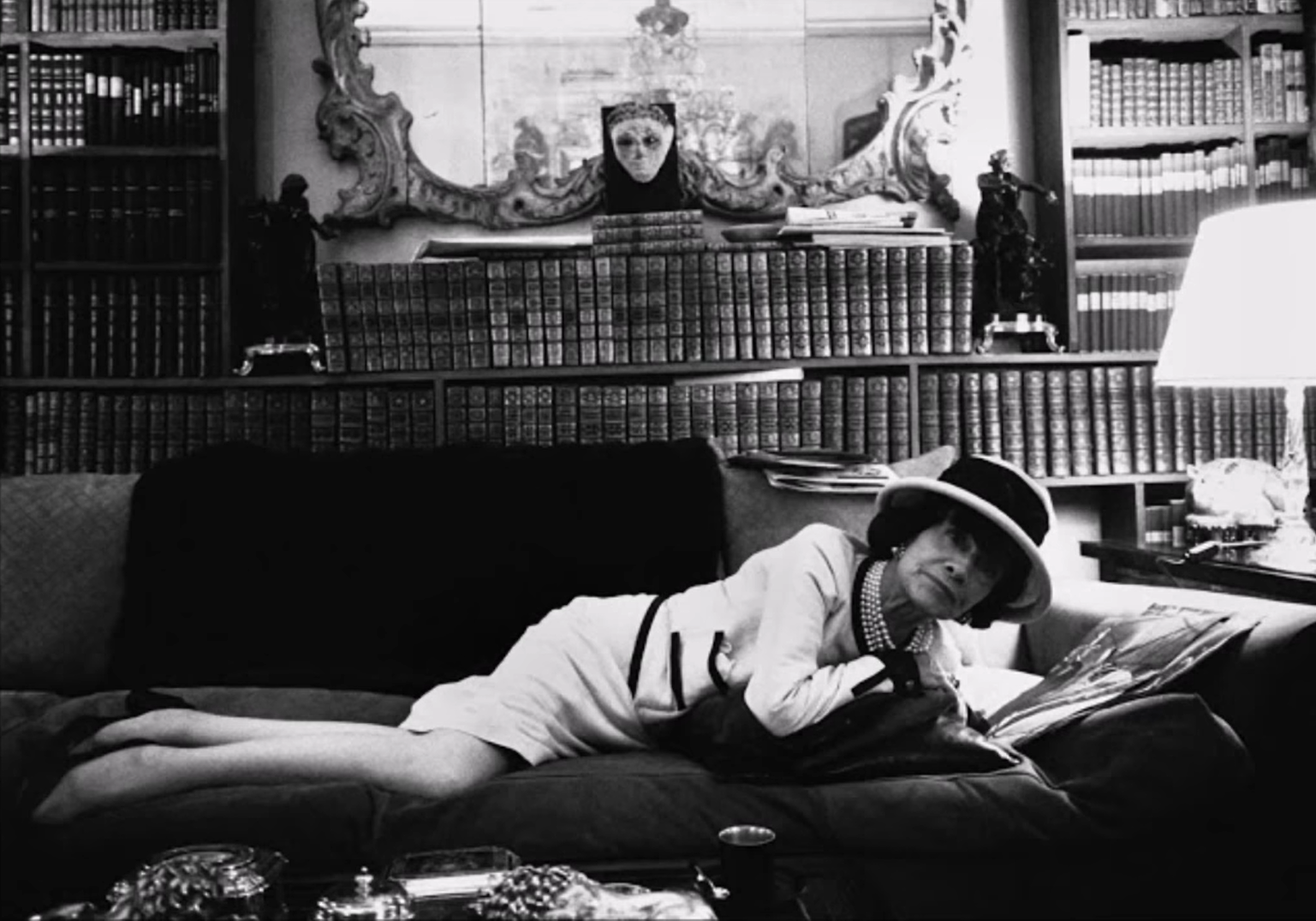 gabrielle chanel on black sofa in her room - black and wite retro photo
